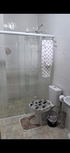 a bathroom with a toilet and a glass shower at House the Dream in Curitiba