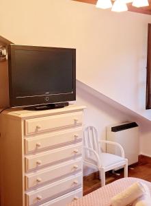 - une chambre avec une télévision au-dessus d'une commode dans l'établissement El mirador de la torre, à Potes