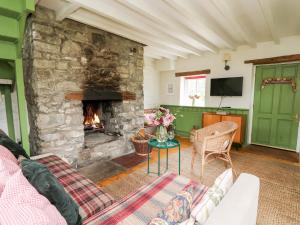 a living room with a stone fireplace and a couch at Red Kite Lodge in Llandeilo