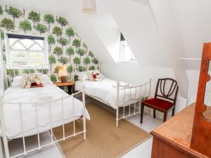a bedroom with two beds and a chair at Red Kite Lodge in Llandeilo