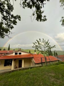 een regenboog in de lucht boven een huis bij Agriturismo Nonno Dante - Casa Moraiolo in Castiglion Fibocchi