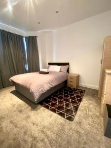 um quarto com uma cama grande e uma janela em Cosy house in Newham em Londres