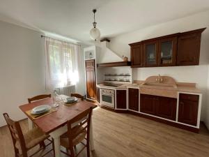 a kitchen with a wooden table and a dining room at Agriturismo Nonno Dante - Casa Moraiolo in Castiglion Fibocchi