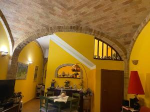 een woonkamer met gele muren en een boog bij Soggiorno da Fiore in Monte Rubiaglio
