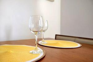 dos copas de vino sentadas sobre una mesa de madera en MALAGA CAMPUS APARTMENT Piscina y Parking incluido, en Málaga