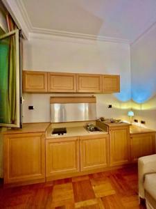 a kitchen with wooden cabinets and a counter top at Auditorium Maxxi luxury suite Roma in Rome