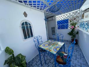 a table and chairs in a room with blue tiles at Charming Cozy house kasbah in Tangier
