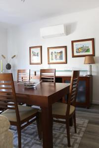 een eetkamer met een houten tafel en stoelen bij ARRUDA LUXURY APARTMENT with AC in Cascais