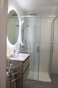 a bathroom with a sink and a shower with a mirror at ARRUDA LUXURY APARTMENT with AC in Cascais