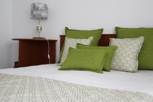 a bed with green and white pillows and a lamp at ARRUDA LUXURY APARTMENT with AC in Cascais