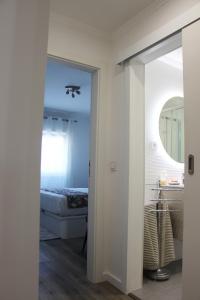 um quarto com uma cama e um espelho em ARRUDA LUXURY APARTMENT with AC em Cascais