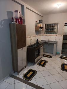 a kitchen with a stove and a counter with mats on the floor at Quarto privativo em casa de condomínio in Cuiabá