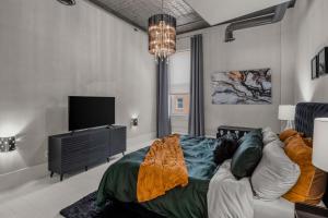 un soggiorno con un divano e una TV di Broadway Luxe Loft a Siloam Springs