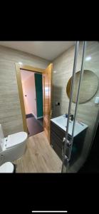 a bathroom with a white toilet and a sink at Villa palmeras in Numancia de la Sagra