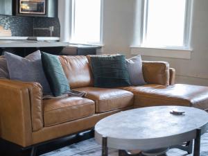 un soggiorno con divano marrone e tavolo di Broadway Luxe Loft a Siloam Springs Altre 12 foto