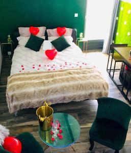 - une chambre avec un lit doté de coeurs rouges dans l'établissement Amo Hôtes, aux Sorinières