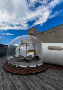 a bed in a glass dome on top of a roof at Hotel Wanderlive in Querétaro