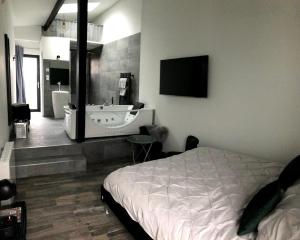 レ・ソリニエールにあるAmo Hôtesのベッドルーム1室(ベッド1台付)、バスルーム(シンク付)