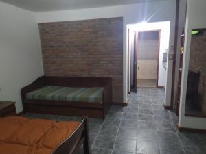 1 dormitorio con cama y pared de ladrillo en La Residenza en Playa Santa Ana