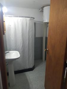 uma casa de banho com uma cortina de chuveiro branca e um lavatório. em La Residenza em Santa Ana