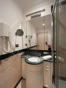 a bathroom with a sink and a shower and a mirror at Auditorium Maxxi luxury suite Roma in Rome