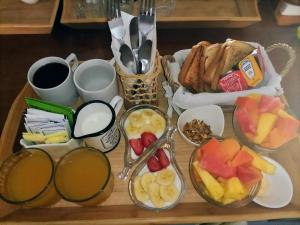 a tray of food with bowls of fruit and toast at Villa Marilu B&B in Bacalar