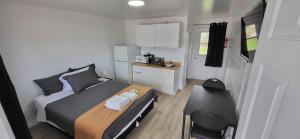 a small bedroom with a bed and a desk at Happyland Inn in Orillia