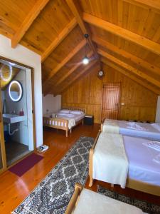 two beds in a room with wooden ceilings at Bixhaku GuestHouse in Gjirokastër