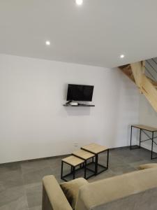 Gîte l'harmonie I في Fraize: غرفة معيشة بها أريكتين وتلفزيون على الحائط