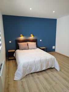 Gîte l'harmonie I في Fraize: غرفة نوم بسرير ابيض كبير بجدار ازرق