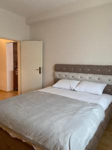 Apartman MARIJA في Bosanski Šamac: غرفة نوم بسرير كبير مع شراشف بيضاء