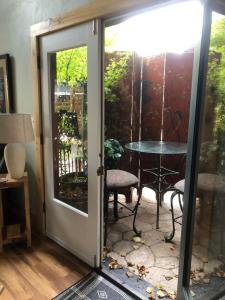 una puerta abierta que conduce a un patio con mesa en Leos Loft en Eugene