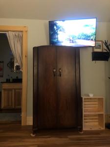 a flat screen tv on top of a wooden cabinet at Leos Loft in Eugene