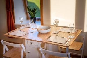 un tavolo in legno con bicchieri da vino e una ciotola sopra di The High Croft a Rogart