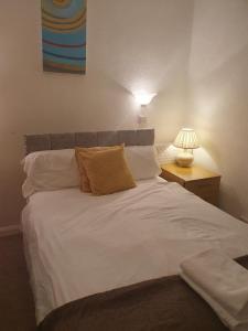um quarto com uma grande cama branca e um candeeiro em Ababeel Hotel em Birmingham
