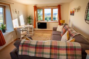 a living room with a couch and a table at The High Croft in Rogart