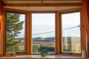 two windows in a room with a view of the mountains at The High Croft in Rogart