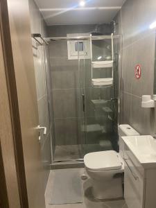 een badkamer met een douche, een toilet en een wastafel bij Leo's Apartments in Koropíon
