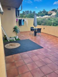 a patio with a table and chairs and an umbrella at Makwande Self-Catering Apartment in Durban