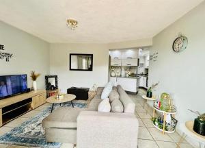 a living room with a couch and a tv at Makwande Self-Catering Apartment in Durban
