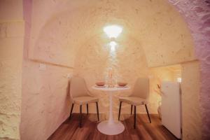a table and chairs in a room with a wall at Romantic Suite with Private Jacuzzi Malely Suite in Martina Franca