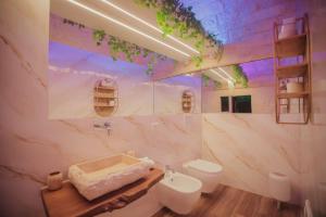 a bathroom with a sink and a toilet at Romantic Suite with Private Jacuzzi Malely Suite in Martina Franca