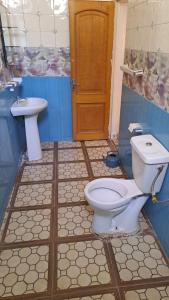 a bathroom with a toilet and a sink at VILLE FRANCE PATOIS in Thiès