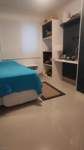 een slaapkamer met een bed met een blauwe deken op de vloer bij Campo dos Lirios in Curitiba