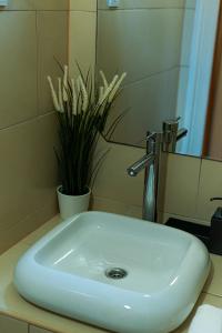 een witte wastafel in een badkamer met een plant bij Cosy Corner - Entire Apartment near Oktogon in Boedapest
