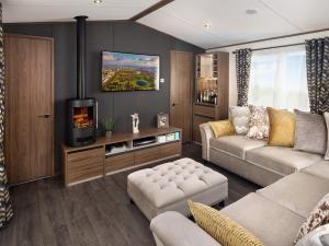 a living room with a couch and a tv at Beachwood 21 in Camber