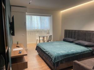 1 dormitorio con cama, mesa y ventana en Downtown Studio Apartments en Tirana