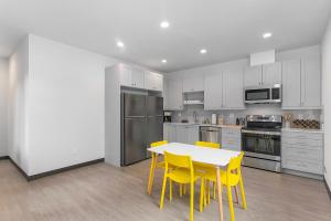 a kitchen with a table and yellow chairs in it at Yoda's Swamp Suite in Seattle