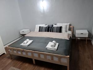 a bed with two towels on top of it at Grey House in Braşov