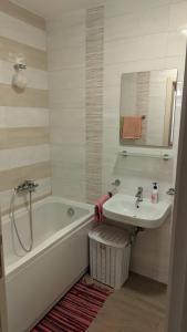 a bathroom with a sink and a bath tub and a sink at Guest House Mikeli (BESPL. DORUCAK)-(FREE BREAKFAST) in Podgorica